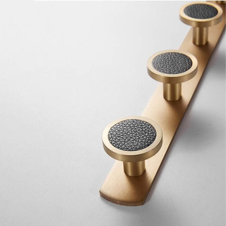 Aan de muur bevestigde kapstok met 5 ronde haken. Kapstokhaken van geborsteld goudkleurig messing. Aan de muur bevestigde handdoekhouder. Haken voor badkamer en woonkamer. Schroefinstallatie. Witte schelp