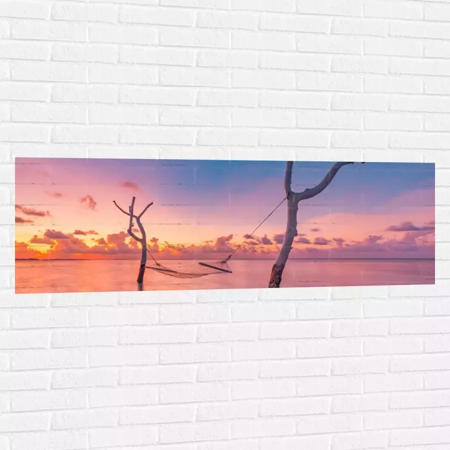Muursticker Hangmat tussen Kale Takken in de Zee tijdens Zonsondergang 150x50 cm Foto op Muursticker