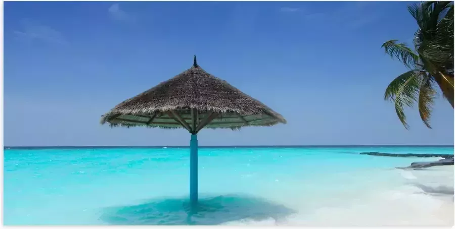 Poster Glanzend – Rieten Parasol op het Strand bij het Blauwe Water 100x50 cm Foto op Posterpapier met Glanzende Afwerking