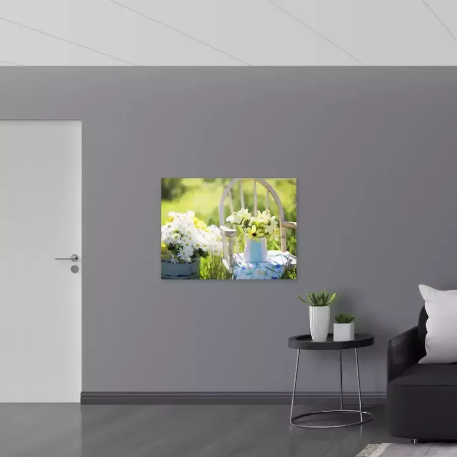 Poster Glanzend – Zakje Bloemen op Witte Traditionele Stoel langs Ton met Bloemen 100x75 cm Foto op Posterpapier met Glanzende Afwerking