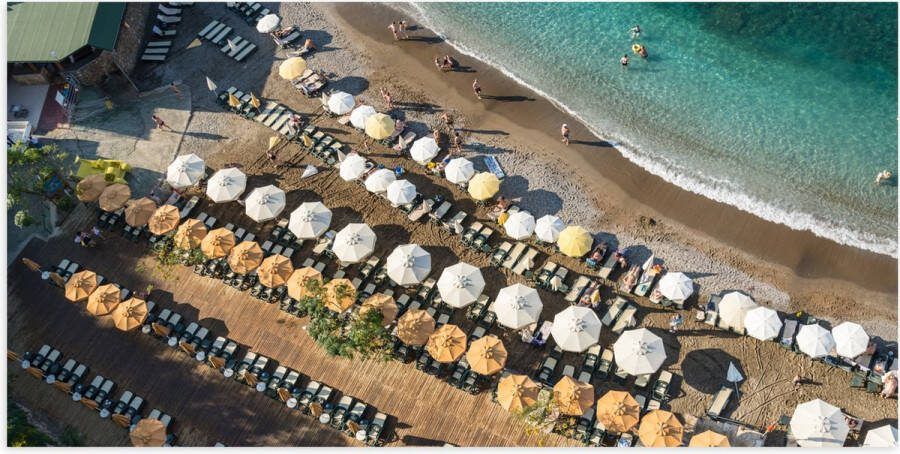 Poster Glanzend – Zee Strand Bedjes Parasols Water Hout Mensen 100x50 cm Foto op Posterpapier met Glanzende Afwerking