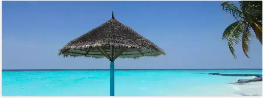Poster (Mat) Rieten Parasol op het Strand bij het Blauwe Water 120x40 cm Foto op Posterpapier met een Matte look