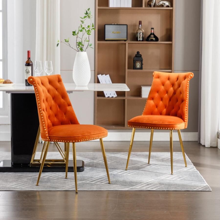 Merlooks Een set van twee zeer zachte fluwelen stoelen met een licht gestoffeerde rug en goudkleurige metalen poten Moderne en opvallende stoelen worden gebruikt in woon en eetkamers Oranje