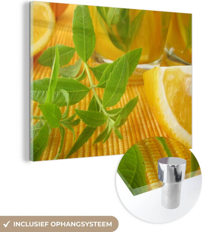MuchoWow Glasschilderij 120x90 cm Schilderij glas Tafel met een citroenverbena takje in een gele omgeving Foto op acrylglas Schilderijen