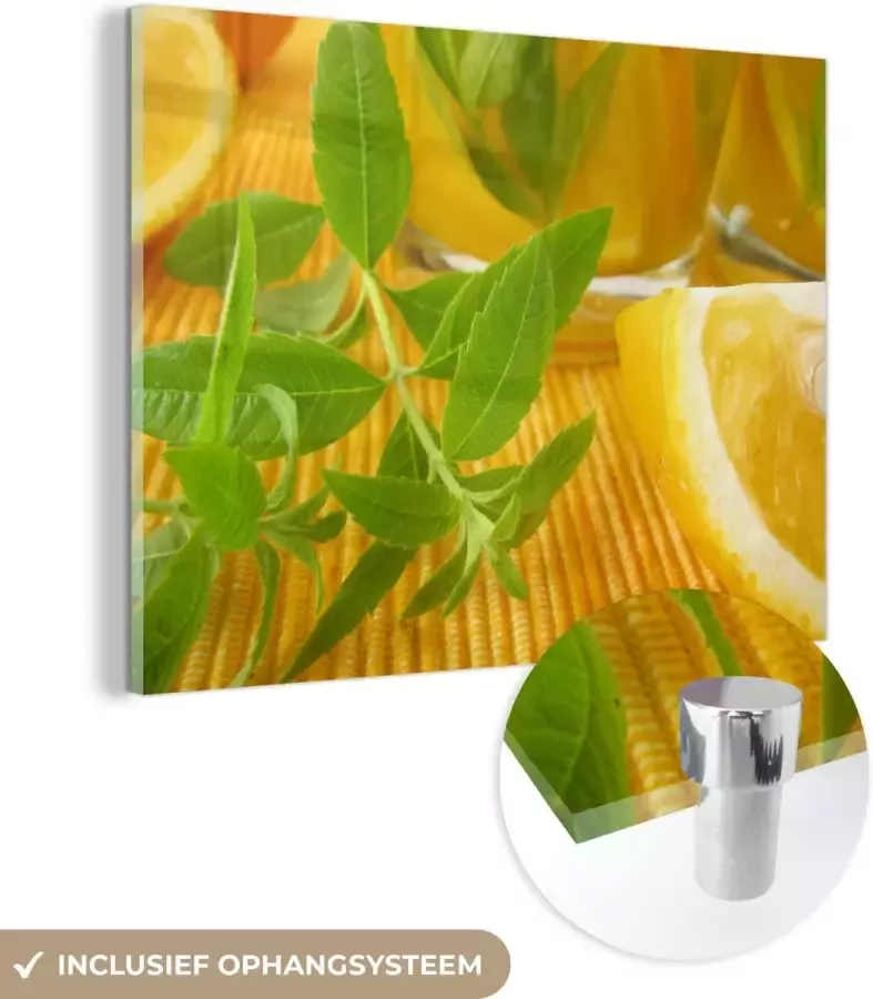 MuchoWow Glasschilderij Tafel met een citroenverbena takje in een gele omgeving 120x90 cm Acrylglas Schilderijen Foto op Glas