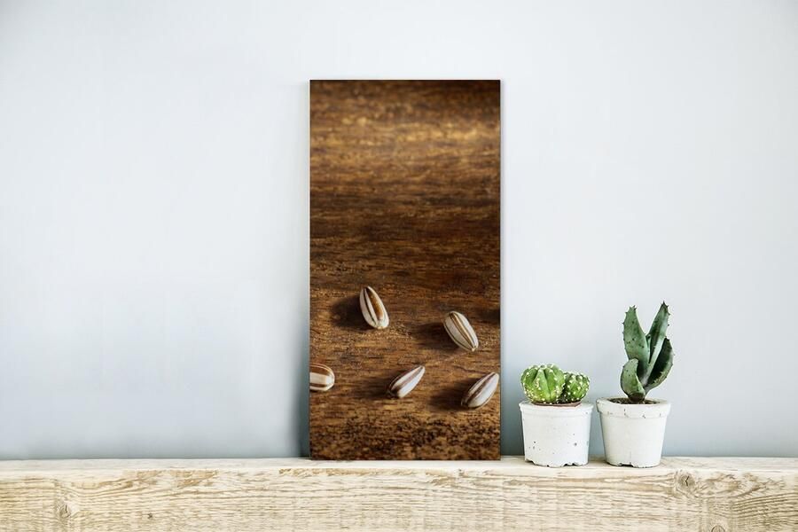 MuchoWow Glasschilderij Tien zonnebloempitten op houten tafel 20x40 cm Acrylglas Schilderijen Foto op Glas