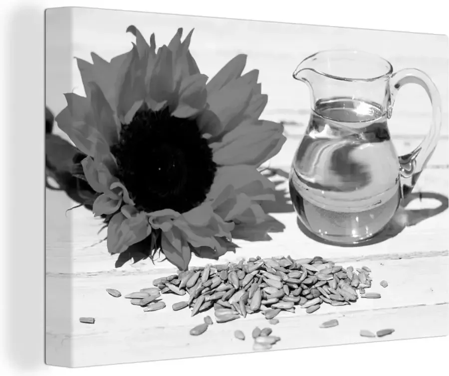 OneMillionCanvasses Canvas Schilderij Zonnebloempitten met zonnebloemolie in een klein glas en zonnebloem op witte tafel zwart wit 90x60 cm Wanddecoratie