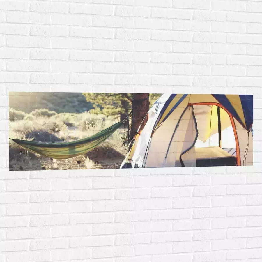 WallClassics Muursticker Hangmat bij Tent in Bos 150x50 cm Foto op Muursticker
