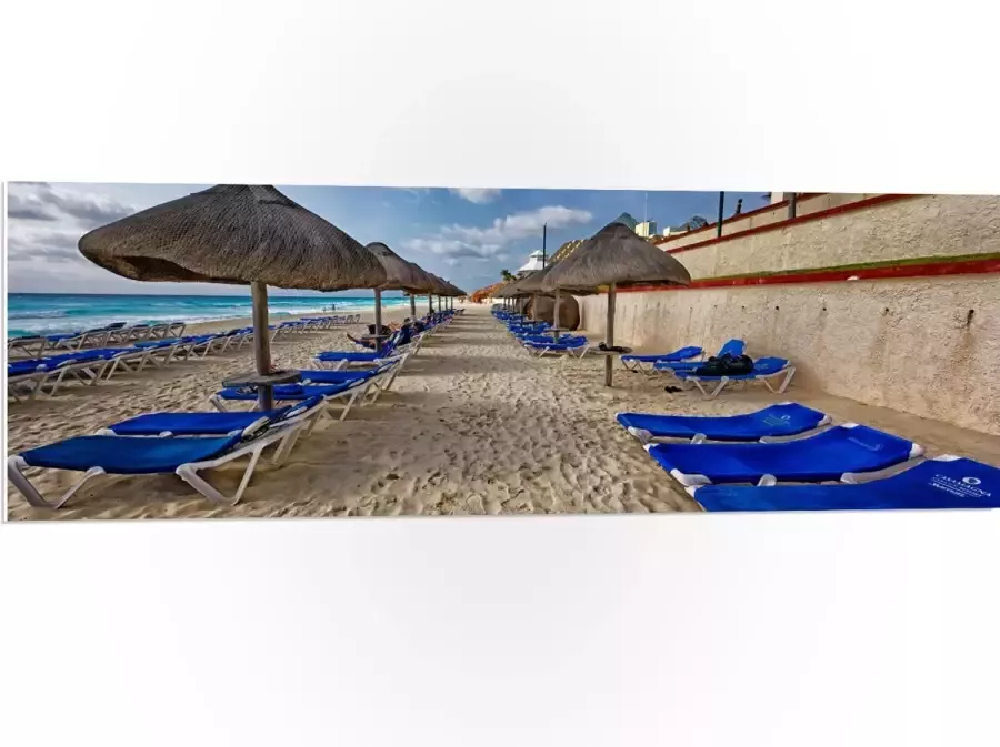 WallClassics PVC Schuimplaat- Blauwe Ligbedden op Strand met Rieten Parasols 120x40 cm Foto op PVC Schuimplaat
